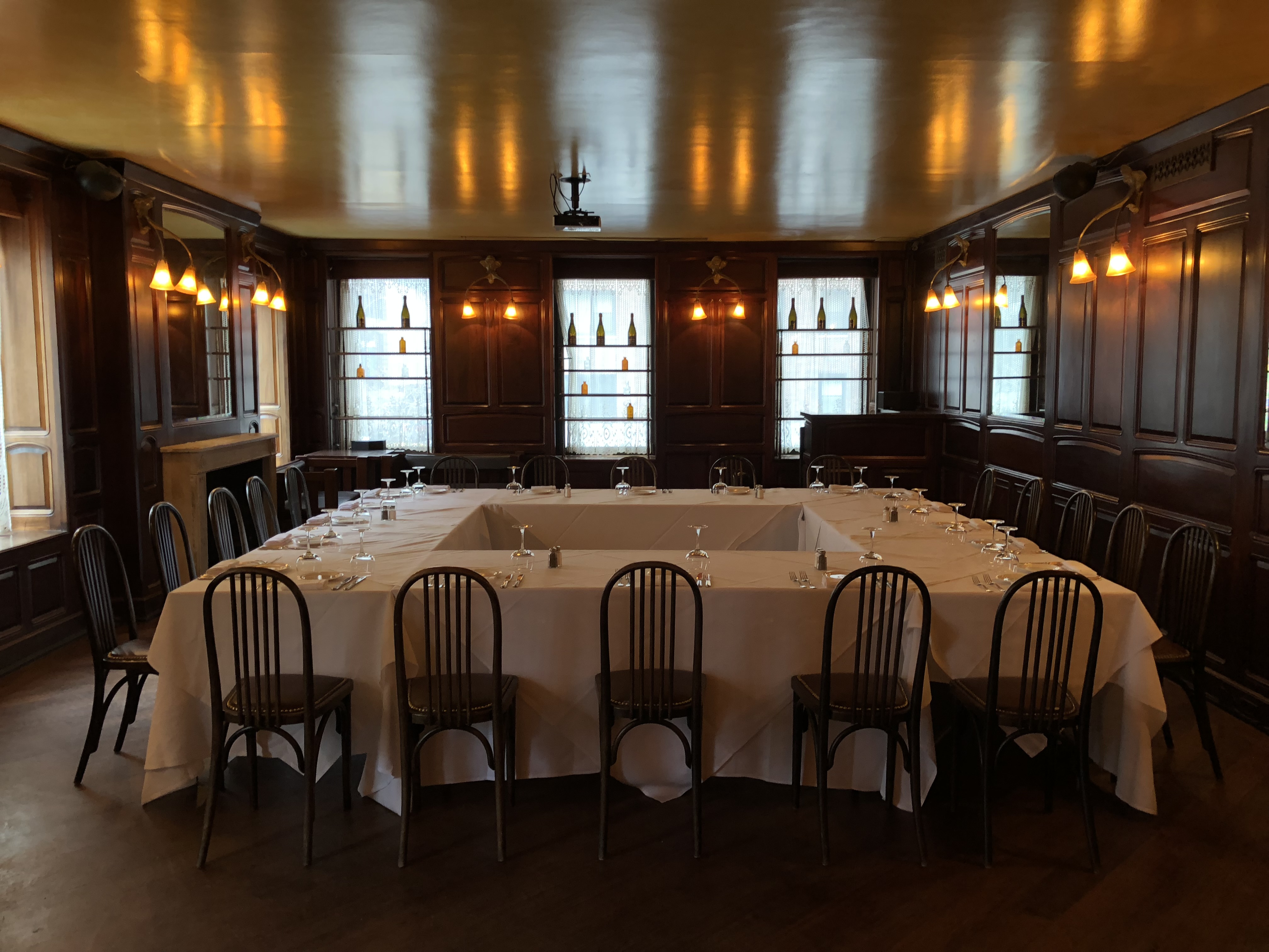 Restaurant chic, lumière tamisée. Une table élégamment dressée pour un dîner festif, prête à accueillir des invités.